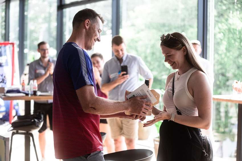 Dominik Klein übergibt ein Franken Körble an eine Partnerin vom Handballcampus München.